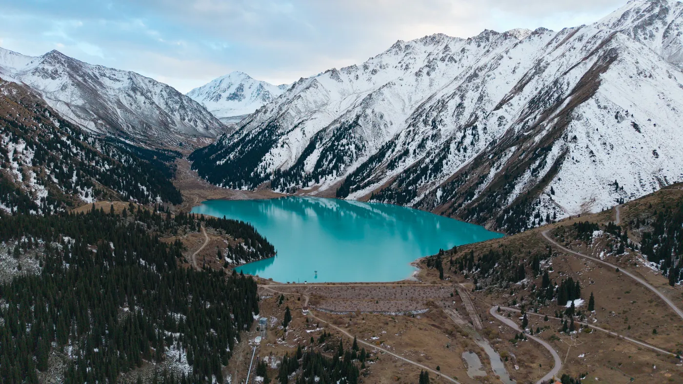 Big Almaty Lake below snowy peaks, seen from above