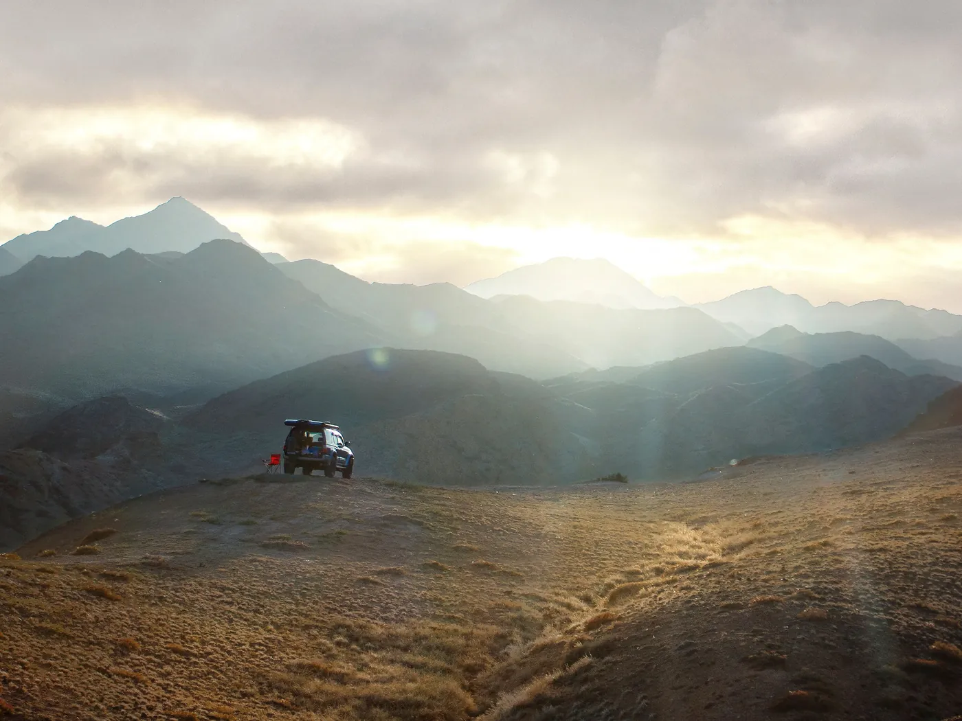 A 4x4 on a mountain valley track in evening light