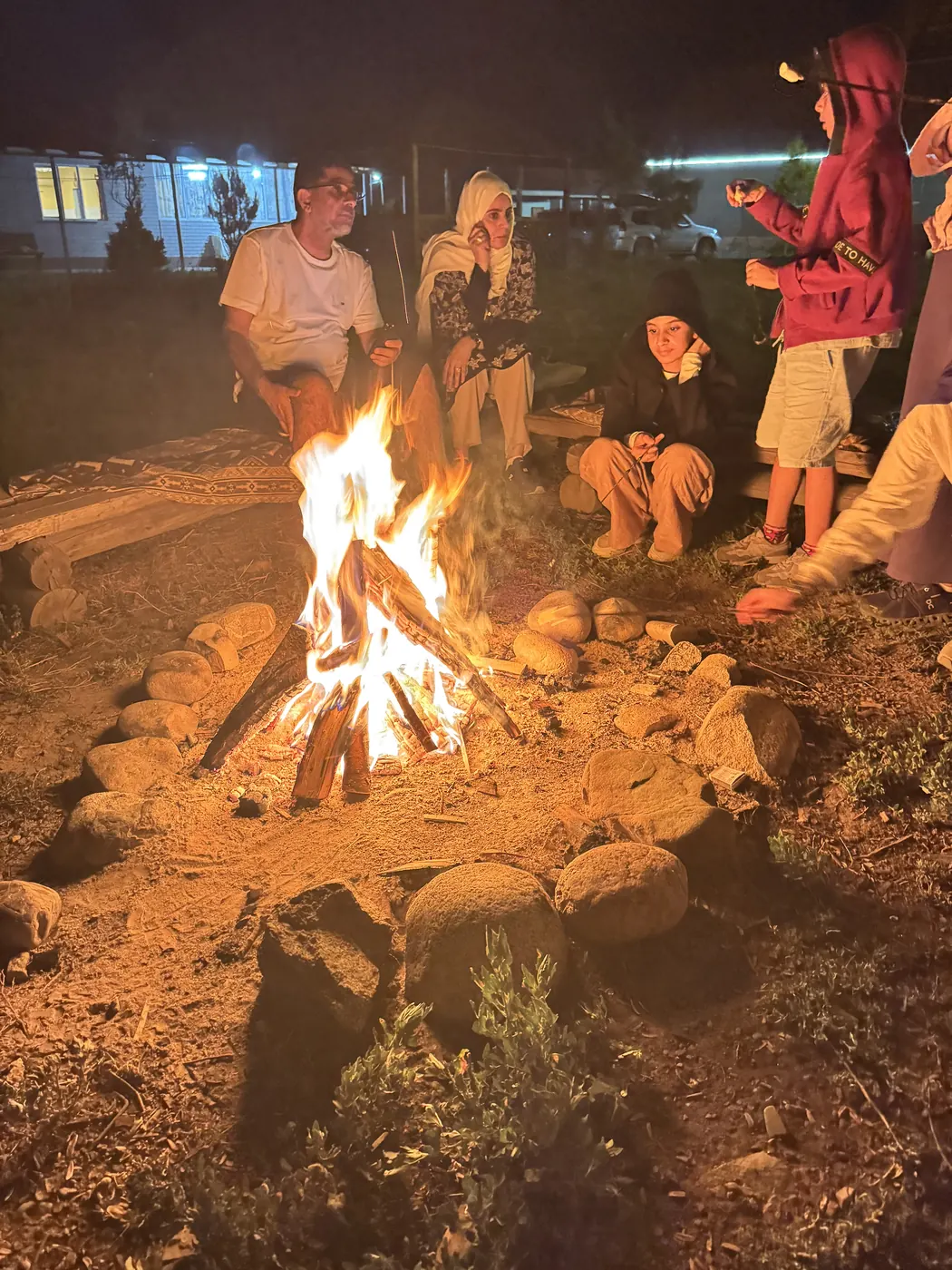 Guests around a campfire at night