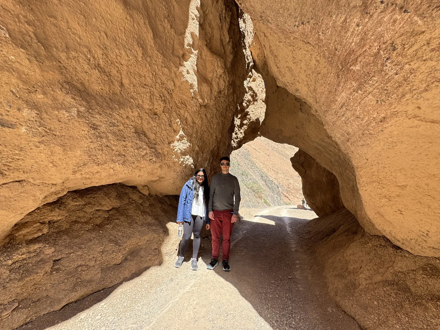 Two travelers in a sandstone arch at Charyn